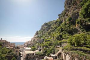 a village on a mountain next to the ocean at Hotel L'Argine Fiorito in Atrani