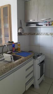 cocina con fregadero y fogones en Apartamento de dois quartos em Ponta Negra - Excelente Localização, en Natal