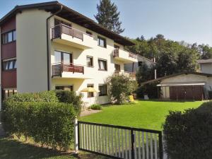 an apartment building with a lawn in front of it at Appartements Margot in Krumpendorf am Wörthersee