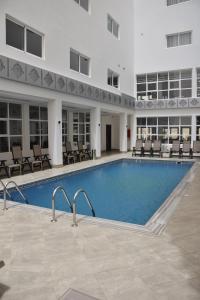 a large swimming pool in a building with chairs at Nouakchott Hotel in Nouakchott