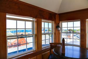 a dining room with a table and three windows at Compass Rose Inn in Newburyport