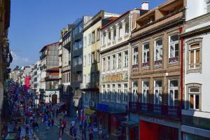 eine Gruppe von Menschen, die eine Straße mit Gebäuden entlang gehen in der Unterkunft My Story Apartments Porto - Santa Catarina in Porto