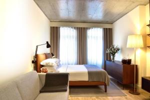 Habitación de hotel con cama y sofá en My Story Apartments Porto - Santa Catarina, en Oporto