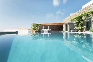 a swimming pool with blue water in front of a house at Villa Fleur De Sel in Fanari