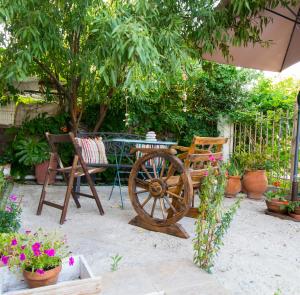 a patio with a table and a bench and flowers at Dream Catcher Artemis in Artemida