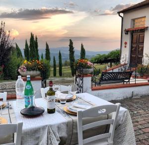 a white table with chairs and bottles of wine at Podere Belvedere in Barberino di Mugello