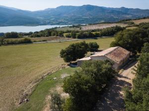 an aerial view of a house in a field with a lake at Mas de Bruquet in Llimiana