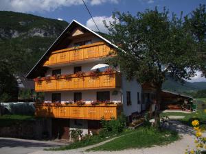 a building with a balcony with flowers on it at Apartmaji Verica Ceklin in Bohinj