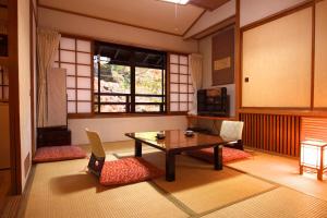a living room with a table, chairs and a coffee table at Tsuruya Ryokan in Karuizawa