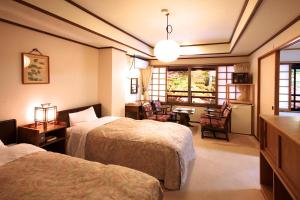 a hotel room with two beds and two lamps at Tsuruya Ryokan in Karuizawa