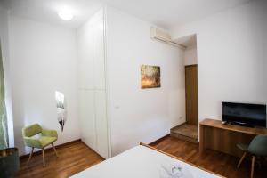 Schlafzimmer mit einem Bett, einem Schreibtisch und einem TV in der Unterkunft Le Camere di Porta San Felice - Self Check in in Bologna