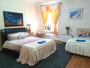 a bedroom with two beds and a window at Gabriel Guesthouse in Rhyl