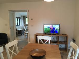 a living room with a television on a table at Ty Glo Cottage in Brecon