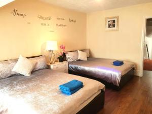 a bedroom with two beds with blue towels on them at Gabriel Guesthouse in Rhyl