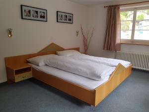 a bed with a wooden frame in a bedroom at Hotel Restaurant Edelweiss in Mühlen