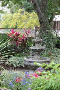 een fontein midden in een tuin met bloemen bij Cedar House Inn in St. Augustine