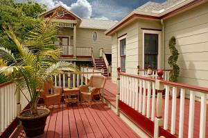 a house with a wooden deck with a potted plant at Cedar House Inn in Saint Augustine