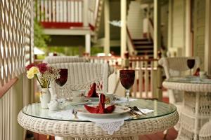 a glass table on a porch with a plate of food at Cedar House Inn in Saint Augustine