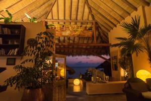 a living room with a view of the ocean at La Casa Que Canta in Zihuatanejo