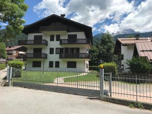 a white house with a fence in front of it at ELDA's Home - Ideale per famiglie in Pinzolo