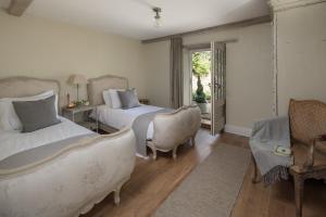a bedroom with two beds and a window at The Cider Barn Boutique Holiday Cottage in Zeal Monachorum