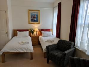 um quarto de hotel com duas camas e uma cadeira em No. 23 em Wells