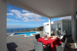 a dining room with a table and a view of the ocean at Villa Por do Sol in Estreito da Calheta