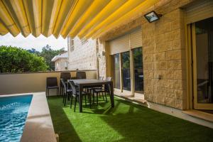 a patio with a table and chairs on the grass at PortoHouse in Porto