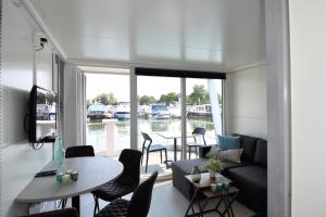 a living room with a couch and a table at Cosy floating boatlodge Athene in Maastricht