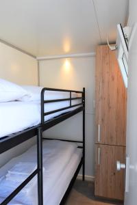 a room with two bunk beds and a wooden cabinet at Cosy floating boatlodge Athene in Maastricht