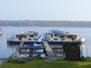 two boats docked at a dock in the water at Boats & Yachts at Zeuthen Marina by Kuhnle-Tours in Zeuthen