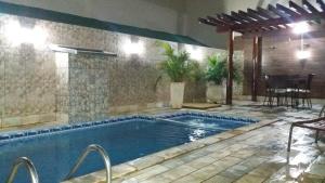 uma piscina num pátio com uma mesa e cadeiras em Casa Temporada Daniel- Olímpia SP em Olímpia