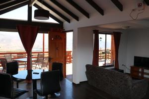 a living room with a table and chairs and a balcony at Cabañas Kakanchik in Vicuña