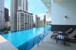 a swimming pool with chairs and a view of a city at Perfect Location#2 @Heart of KL City Centre next to Metro MRT in Kuala Lumpur