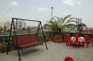 a swing on a balcony with a table and chairs at Park Palace Hotel in Kolkata