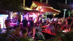 uma multidão de pessoas sentadas num bar à noite em Seabreeze Hotel Kohchang em Ko Chang