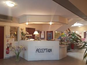 una zona de recepción de una floristería con mostrador de recepción en Hôtel Point Bleu, en Frontignan