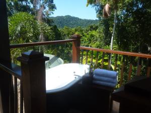 a bath tub on a deck with a view at Daintree Holiday Homes - Yurara in Cow Bay