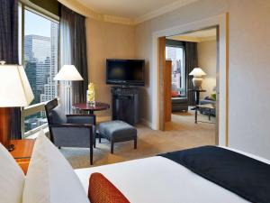 a bedroom with a bed and a living room with a television at Sofitel New York in New York