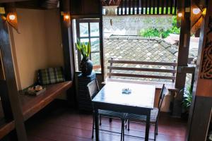 a dining room with a table and chairs and a window at The North Hotel in Chiang Rai