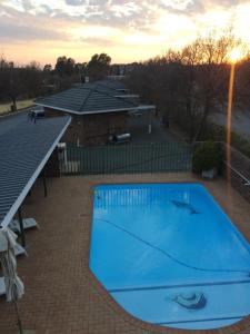 a large blue swimming pool on a brick patio at Sunset Chalets in Colesberg