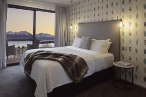 a bedroom with a large bed with a large window at Ranginui At Lake Tekapo in Lake Tekapo