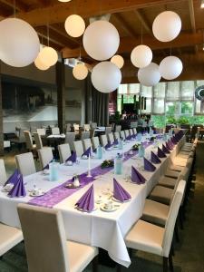 a long dining room with white tables and chairs at Landhotel Bad Dürrenberg in Bad Dürrenberg