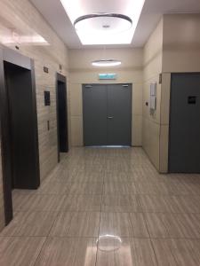 an empty hallway with doors and tile floors at Meridin Medini Muslim Condo in Nusajaya