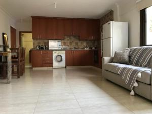 a living room with a couch and a kitchen at Mystra Place in Nicosia