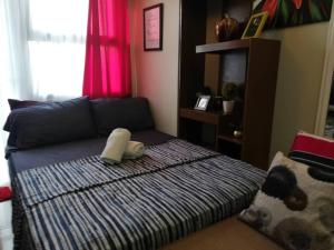 uma cama num quarto com uma almofada em Nica's Place Property Management Services at Horizons 101 Condominium em Cebu