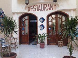 un ristorante con due porte e due piante in vaso di Al Hambra Hotel a Luxor