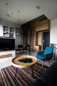 uma sala de estar com um sofá azul e uma mesa em G - Owl Jazz - Modern and spacious loft type apartment 8 with free private parking em Kaunas