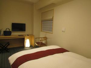 Un pat sau paturi într-o cameră la Japanese Style Hotel Isomura