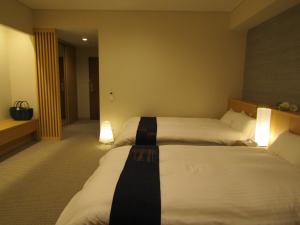 Uma cama ou camas num quarto em Japanese Style Hotel Isomura
